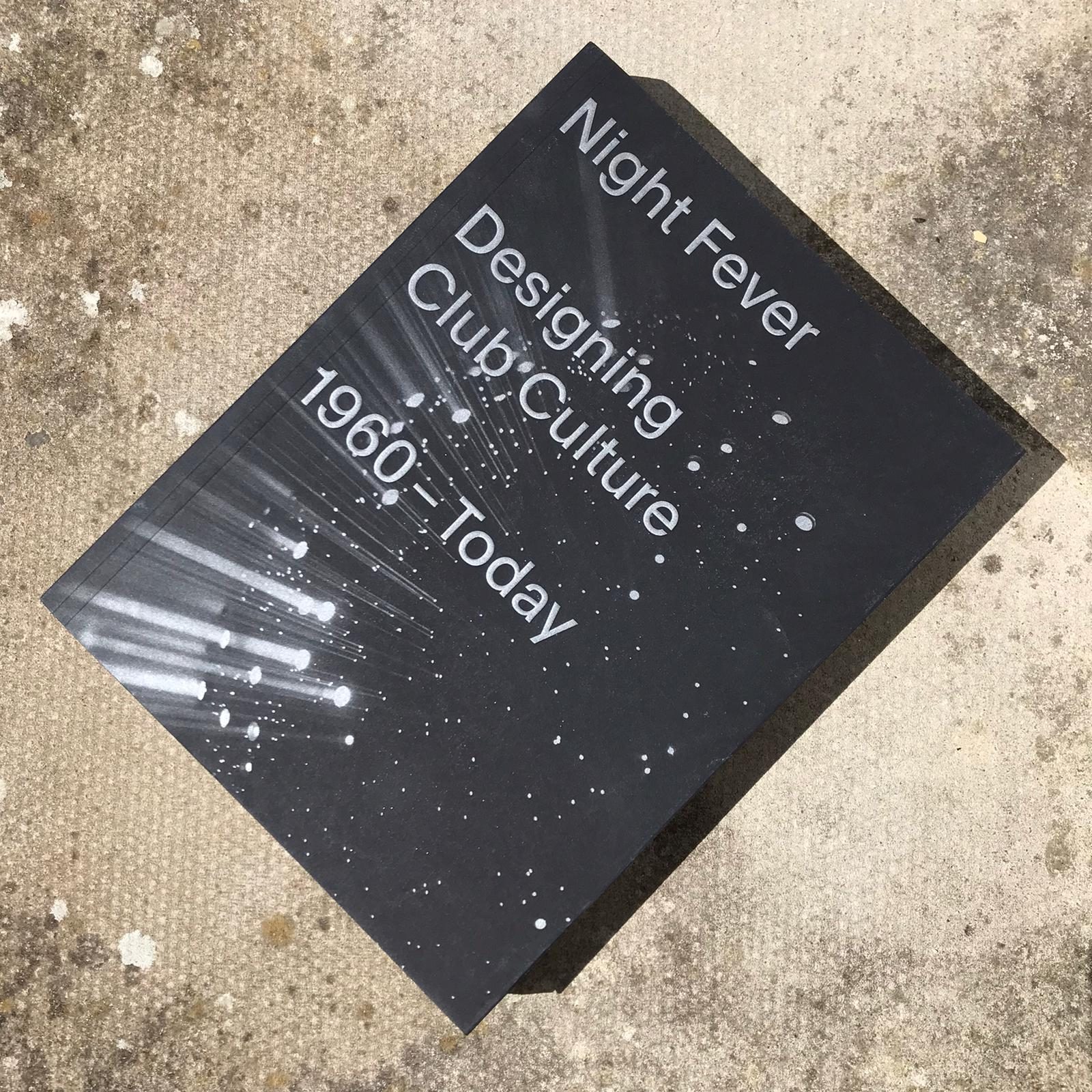 Photograph of the book 'Night Fever: Designing Club Culture' on a concrete background.